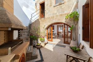 un patio esterno con panca in legno e un edificio di Villa Valasia Lindos with Acropolis View a Líndos