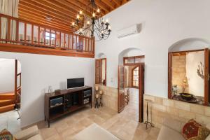 un soggiorno con un divano e una televisione di Villa Valasia Lindos with Acropolis View a Líndos