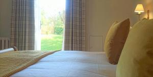a bedroom with a bed with a large window at The Mill, Long Melford in Long Melford