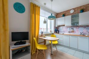 a kitchen with a small table and yellow chairs at Maria Apartment in Saint Petersburg