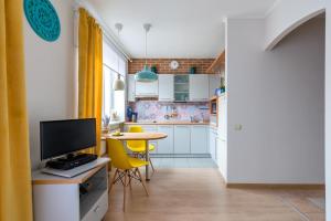 a small kitchen with a table and yellow chairs at Maria Apartment in Saint Petersburg