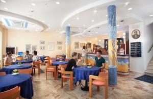 een restaurant met blauwe tafels en mensen die er zitten bij Hotel Rio Bellaria in Bellaria-Igea Marina