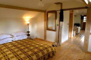 a bedroom with a large bed and a mirror at Glanwye in Hay-on-Wye