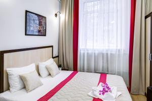 モスクワにあるミニマ ディナモのベッドルーム1室(ピンクと白のシーツが備わるベッド1台付)