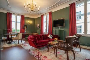 a living room with a red couch and a table at The Apartments Company - The Sweet in Oslo