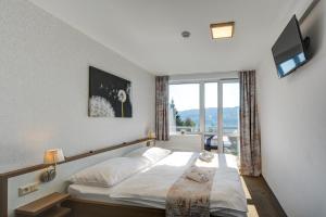 um quarto de hotel com uma cama e uma janela em Hotel STAR Lipno em Lipno nad Vltavou