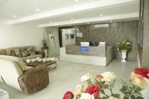 a lobby with a waiting room with a couch and flowers at HOTEL HABANA REAL in Apartadó