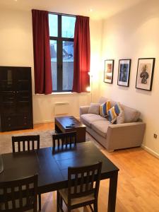 a living room with a couch and a table at Stylish City Centre Apartment in Cardiff
