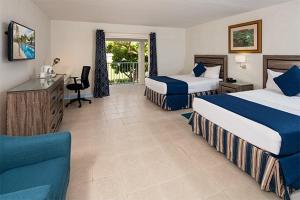 a hotel room with two beds and a desk at Time Out Hotel in Christ Church