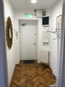 pasillo con puerta blanca y suelo de madera en VICTORIA LUXURY APARTMENT, en Bucarest