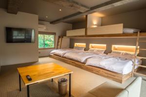 箱根WPÜ HOTEL HAKONE的一间卧室设有两张双层床和一张桌子