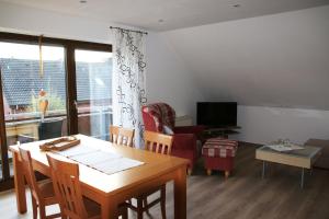 a living room with a table and chairs and a television at Ferienwohnung Hohenholte in Havixbeck