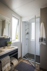 een badkamer met een douche en een wastafel bij Camping Pascalounet in La Couronne