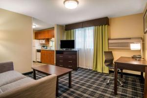 a living room with a couch and a desk in a room at Quality Inn & Suites in Albany