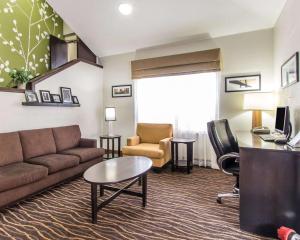 a living room with a couch and a chair and a desk at The Douillet by Demeure Hotels in Oklahoma City