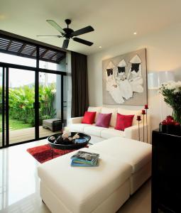 a living room with a white couch and red pillows at Two Villas Holiday Phuket: Onyx Style Nai Harn Beach in Nai Harn Beach
