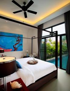 a bedroom with a bed with a ceiling fan at Two Villas Holiday Phuket: Onyx Style Nai Harn Beach in Nai Harn Beach