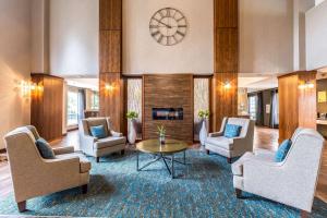 a lobby with chairs and a table and a clock at Clarion Hotel Portland International Airport in Portland