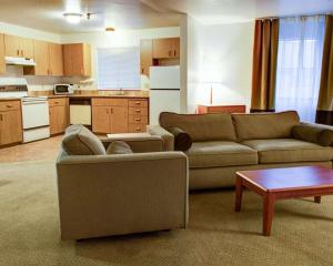 a living room with a couch and a table and a kitchen at Quality Inn Florence in Florence