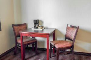 a table with two chairs and a coffee maker on it at Bridgeway Inn & Suites in Sublimity