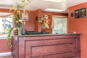 a large wooden bar in a room with orange walls at Rodeway Inn Medford in Medford