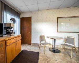 a room with a table and two chairs and a kitchen at Rodeway Inn & Suites in Arlington