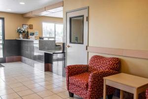 a waiting room with a chair and a table at Bridgeway Inn & Suites in Sublimity