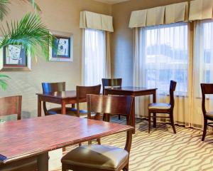 a restaurant with wooden tables and chairs and windows at Quality Inn Florence in Florence