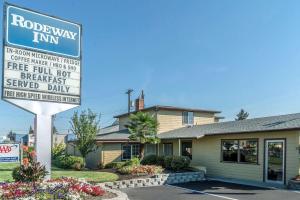 a road sweep inn sign in front of a house at Rodeway Inn Medford in Medford