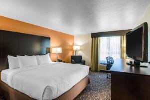 a hotel room with a bed and a flat screen tv at Comfort Inn & Suites in Ashland