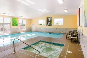 uma grande piscina com uma banheira de hidromassagem num quarto em Comfort Inn & Suites em Ashland