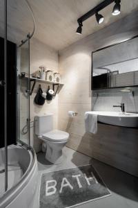 a bathroom with a sink and a toilet and a bath tub at Fisher House in Sopot