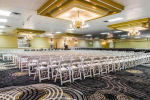 a large banquet hall with rows of white chairs at Quality Inn in New Kensington