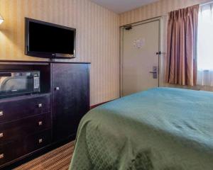 a hotel room with a bed and a flat screen tv at Quality Inn Barkeyville in Barkeyville