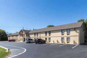 a large tan building with cars parked in a parking lot at Econo Lodge Harrisburg - Southwest of Hershey Area in Harrisburg