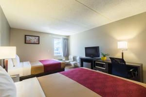 a hotel room with two beds and a flat screen tv at Econo Lodge Harrisburg Southwest of Hershey Area in Harrisburg
