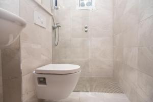 a bathroom with a white toilet and a shower at Apartments Lavanda in Vinišće +55 photos
