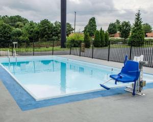 une chaise bleue assise au bord de la piscine dans l'établissement SureStay Plus by Best Western Jonestown Lebanon Valley, à Jonestown