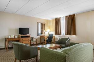 a hotel room with chairs and a table and a tv at Quality Inn & Suites Fairview in Fairview