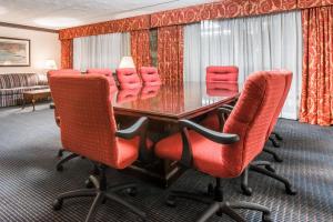 a conference room with a table and red chairs at Quality Inn & Conference Center in Somerset