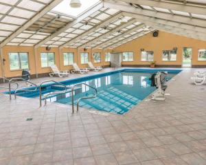 ein großer Pool mit Treppen in einem Gebäude in der Unterkunft Rodeway Inn in Mercer