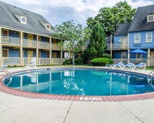 a large swimming pool in front of a building with chairs at Clarion Inn Strasburg - Lancaster in Strasburg