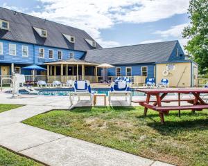 a house with a pool and a picnic table and chairs at Clarion Inn Strasburg - Lancaster in Strasburg