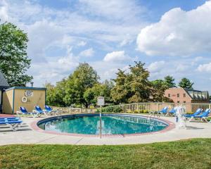 a swimming pool with chairs and a volley ball court at Clarion Inn Strasburg - Lancaster in Strasburg