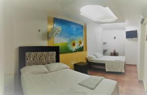 a room with two beds and a painting on the wall at Encanto Hotel Boutique in Santa Marta +93 photos
