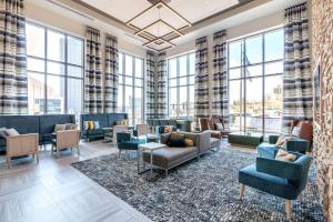 a lobby with couches and chairs and large windows at Cambria Hotel Pittsburgh - Downtown in Pittsburgh