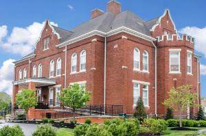 duży budynek z czerwonej cegły z szarym dachem w obiekcie The Federal Pointe Inn Gettysburg, Ascend Hotel Collection w mieście Gettysburg