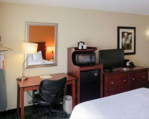 ein Hotelzimmer mit einem Schreibtisch, einem Bett und einem TV in der Unterkunft Quality Inn Cranberry Township in Cranberry Township