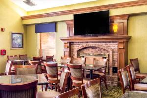 a restaurant with tables and chairs and a fireplace at Clarion Inn in Cranberry Township
