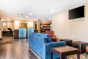 Comfort Inn في تشامبرسبورغ: غرفة معيشة مع أريكة زرقاء وتلفزيون